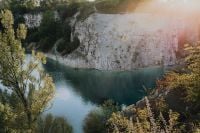 Kaboompics - Sunlit Limestone Cliffs Beside Turquoise Quarry Water
