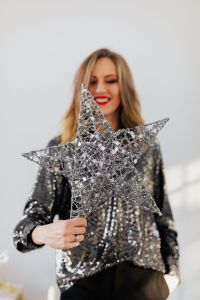 Kaboompics - Woman Holding a Large Silver Star in a Glamorous Christmas Look