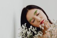 Kaboompics - Eyes-Closed Portrait with Grass-Styled Eyebrows and White Baby's Breath Foreground