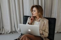 Kaboompics - Thoughtful Businesswoman at Laptop in a Neutral Office