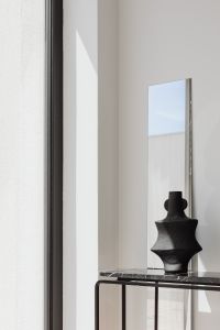 Kaboompics - Black Vase Reflected In Mirror Above Marble Console