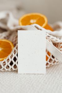 Kaboompics - Blank Business Card against Sliced Orange and Cotton Net Texture