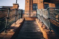 Kaboompics - Sunlit Brick Staircase with Metal Railings and a Pedestrian