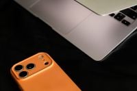 Kaboompics - Orange Phone and Laptop Close Up on Black Leather Sofa