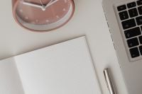 Kaboompics - Pink Clock and Laptop Framing a Blank Notebook