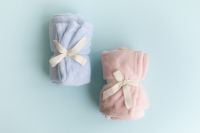 Kaboompics - Pastel Blue And Pink Blankets Tied With Ribbon On Light Blue Background