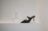 Kaboompics - Black Stiletto Mule on Minimal White Shelf