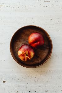 Kaboompics - Top View of Peaches in Wooden Bowl with Minimal Copy Space