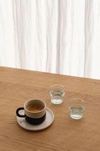 Kaboompics - Coffee Mug and Clear Water Glasses Beside Sheer Curtains