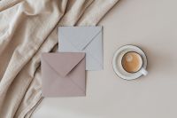Kaboompics - Blush and White Envelopes with Coffee Cup on Linen for Invitation Mockups