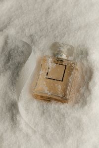 Kaboompics - Perfume Bottle in Artificial Snow with White Ribbon
