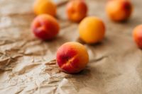 Kaboompics - Peach-Blushed Apricot in Macro on a Rustic Paper Surface, Organic Summer Background