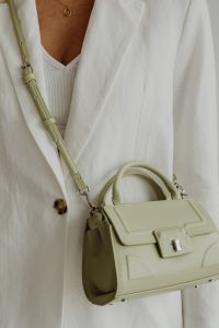 Kaboompics - Sage Green Crossbody Strap and Pendant Necklace Styled with White Jacket