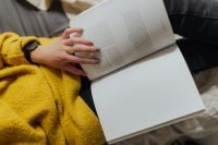 Kaboompics - Woman Reading an Open Book with Her Hand Turning a Page, Home Lifestyle