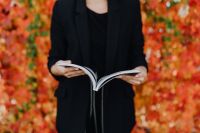 Kaboompics - Centered Open Grafconf Book Held by a Woman in Black with Orange Autumn Leaves