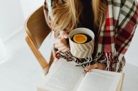Kaboompics - Woman Holding Tea While Reading an Open Book