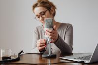 Kaboompics - Woman Recording ASMR at a Desk with Microphone, Laptop and Coffee