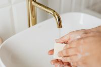Kaboompics - Close-Up of Hands Lathering Soap beneath Brass Faucet for Hand Hygiene Campaign