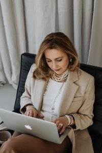 Kaboompics - Smiling Businesswoman Looking at Laptop in a Neutral Home Office