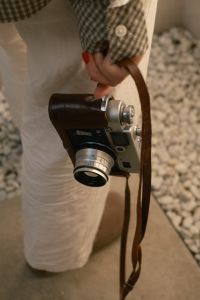 Kaboompics - Vintage Rangefinder Camera Held By The Leather Strap