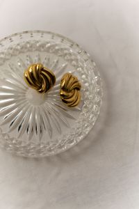Kaboompics - Gold Twisted Earrings on Glass Plate