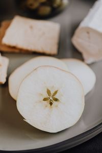 Kaboompics - Sliced Fresh Apple in Foreground with Crispbread and Soft Cheese, Vertical Healthy Snack Photo