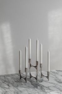Kaboompics - Chrome Five-Candle Candelabra on Marble Table Against Soft White Wall, Minimalist Home Decor