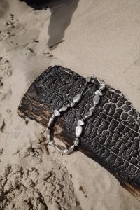 Kaboompics - Silver Necklace on Driftwood in the Sand