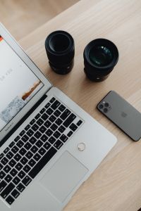 Photographer's Desk Setup with Laptop, Smartphone and Camera Gear