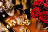 Kaboompics - Champagne Glasses and Red Roses in Golden New Year's Eve Party Light