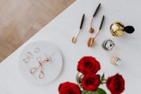 Kaboompics - Red roses, gold rings, perfume brushes and make-up accessories on white marble