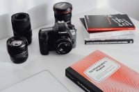 Kaboompics - Photographer's desk - books, DSLR camera and lenses