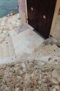 Kaboompics - Dark Wooden Seaside Door Framed by Pink Marble in Rovinj