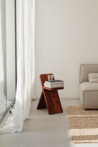 Kaboompics - Minimalist Living Room with Wooden Stool, Books, Water Glass and Gray Sofa