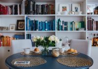 Kaboompics - Round breakfast table with white flowers by the bookcase