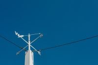 Kaboompics - Cardinal Compass Arrows on a White Pole Against Blue Sky, Wide Copy Space