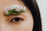 Kaboompics - Asian Woman's Eye Close-Up with Glitter Makeup and White Wildflower Eyebrow