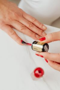 Kaboompics - Vertical Close-Up of Red Nail Polish Being Applied on a Fingernail