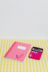 Kaboompics - Vertical Flat Lay of a Pink Notebook, Calculator and Math Symbol