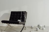 Kaboompics - Black Lounge Chair with Scattered Disco Balls and Minimal White Background