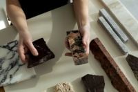 Kaboompics - Hands Comparing Dark Stone and Decorative Material Samples