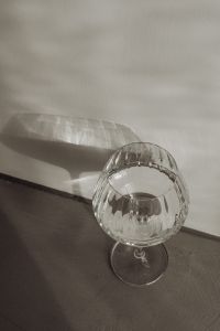 Kaboompics - Top-Down Glass and Long Ribbed Shadow on a Beige Wall