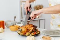 Kaboompics - Woman Slicing Roast Turkey beside a Festive Table Setting
