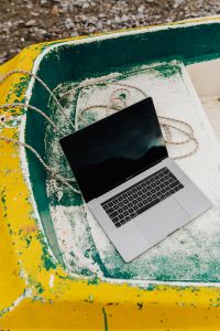 Kaboompics - Open MacBook Laptop Inside a Boat on a Pebble Shore