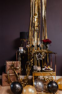 Kaboompics - Gold Streamer Party Display with Champagne, Star Ornament and Small Wrapped Presents