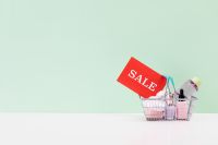 Kaboompics - Red Sale Sign in Shopping Basket on Mint Green Background
