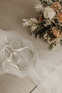 Kaboompics - Bridal Tiara and Bouquet with Sheer Veil on Neutral Fabric