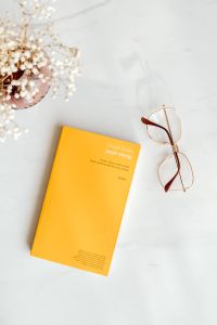 Kaboompics - Orange Book, Eyeglasses And Dried Flowers On Marble
