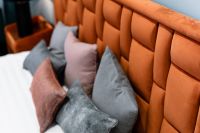 Kaboompics - Upholstered orange bed - pillows