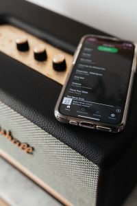 Kaboompics - Black speaker on marble table, white wall, mobile phone